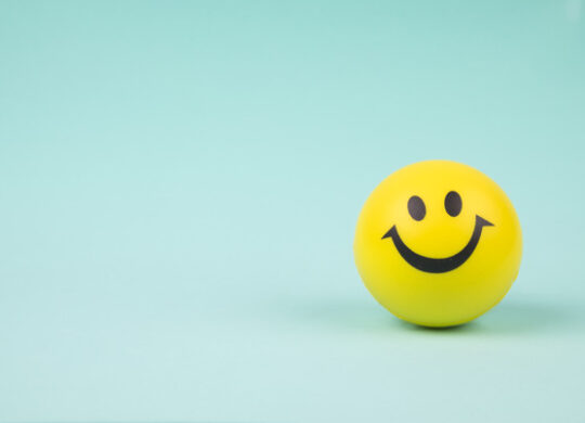 Yellow laughing happy smile face. Smiley face ball on background sweet retro vintage color.